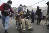 A patient is transferred after angry lawyers staged an attack on a hospital in Lahore, Pakistan, Wednesday, Dec. 11, 2019. Hundreds of Pakistani lawyers, angered over alleged misbehavior of some doctors toward one of their colleagues last month, stormed a cardiology hospital in the eastern city of Lahore, setting off scuffles with the facility's staff and guards that left heart patients unattended for several hours. (AP Photo/K.M. Chaudary)