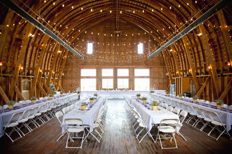 Tables and chairs are set up inside a wedding reception venue