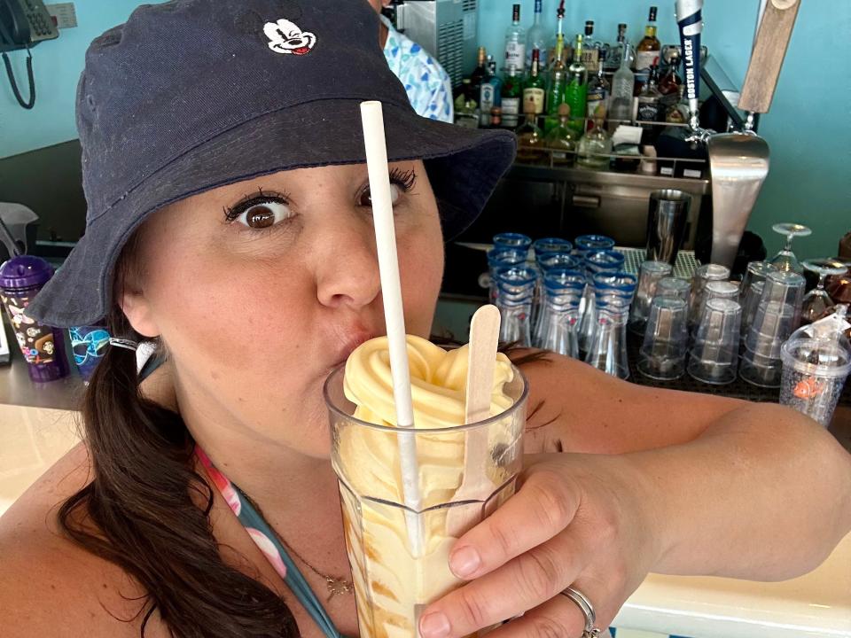 Carly holding a Dole Whip spiked with rum.