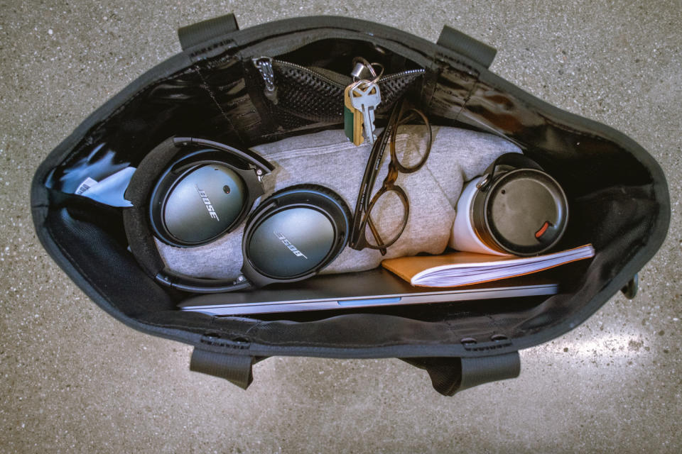 interior of North face tote bag with headphones, notebooks and a laptop