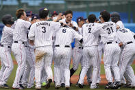 Japan players celebrate a walk-off single hit by Hayato Sakamoto in a baseball game against the Dominican Republic at the 2020 Summer Olympics, Wednesday, July 28, 2021, in Fukushima, Japan. Japan won 4-3. (AP Photo/Jae C. Hong)