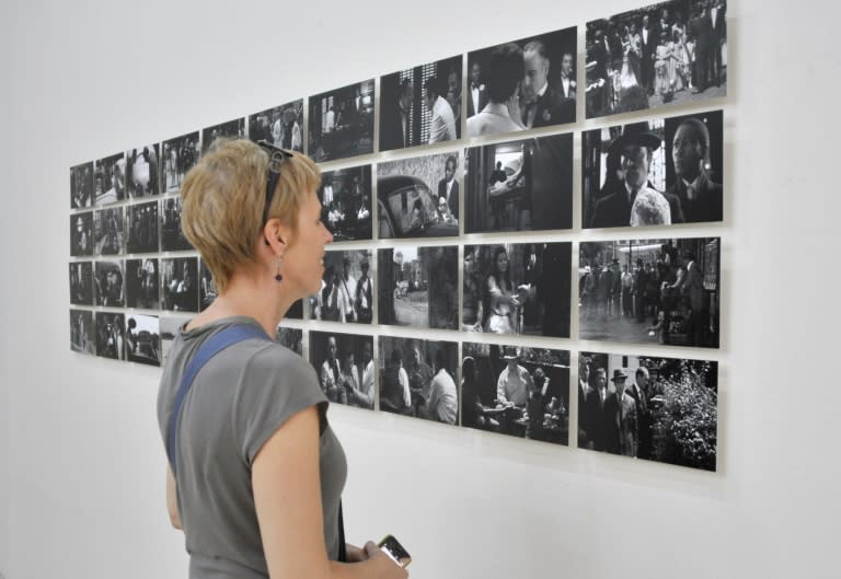 A woman looks at photos taken by Nigerian photographer Uche Okpa-Iroha on November 5, 2015 at the Modibo Keita museum in Mali's capital Bamako