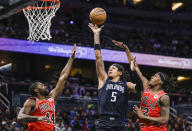 Orlando Magic forward Paolo Banchero (5) shoots from between between Chicago Bulls forward Patrick Williams (44) and guard Ayo Dosunmu (12) during the first half of an NBA basketball game Saturday, Jan. 28, 2023, in Orlando, Fla. (AP Photo/Kevin Kolczynski)