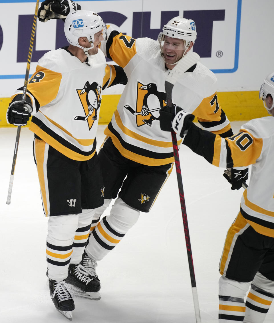 Pittsburgh Penguins center Jeff Carter, center, celebrates after scoring a goal with defenseman Brian Dumoulin, left, and left wing Drew O'Connor in the third period of an NHL hockey game against the Colorado Avalanche Wednesday, March 22, 2023, in Denver. (AP Photo/David Zalubowski)