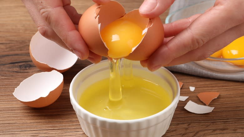 cracking egg white into bowl