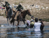 U.S. Customs and Border Protection mounted officers attempt to contain migrants as they cross the Rio Grande from Ciudad Acuña, Mexico, into Del Rio, Texas, Sunday, Sept. 19, 2021. Thousands of Haitian migrants have been arriving to Del Rio, Texas, as authorities attempt to close the border to stop the flow of migrants. (AP Photo/Felix Marquez)