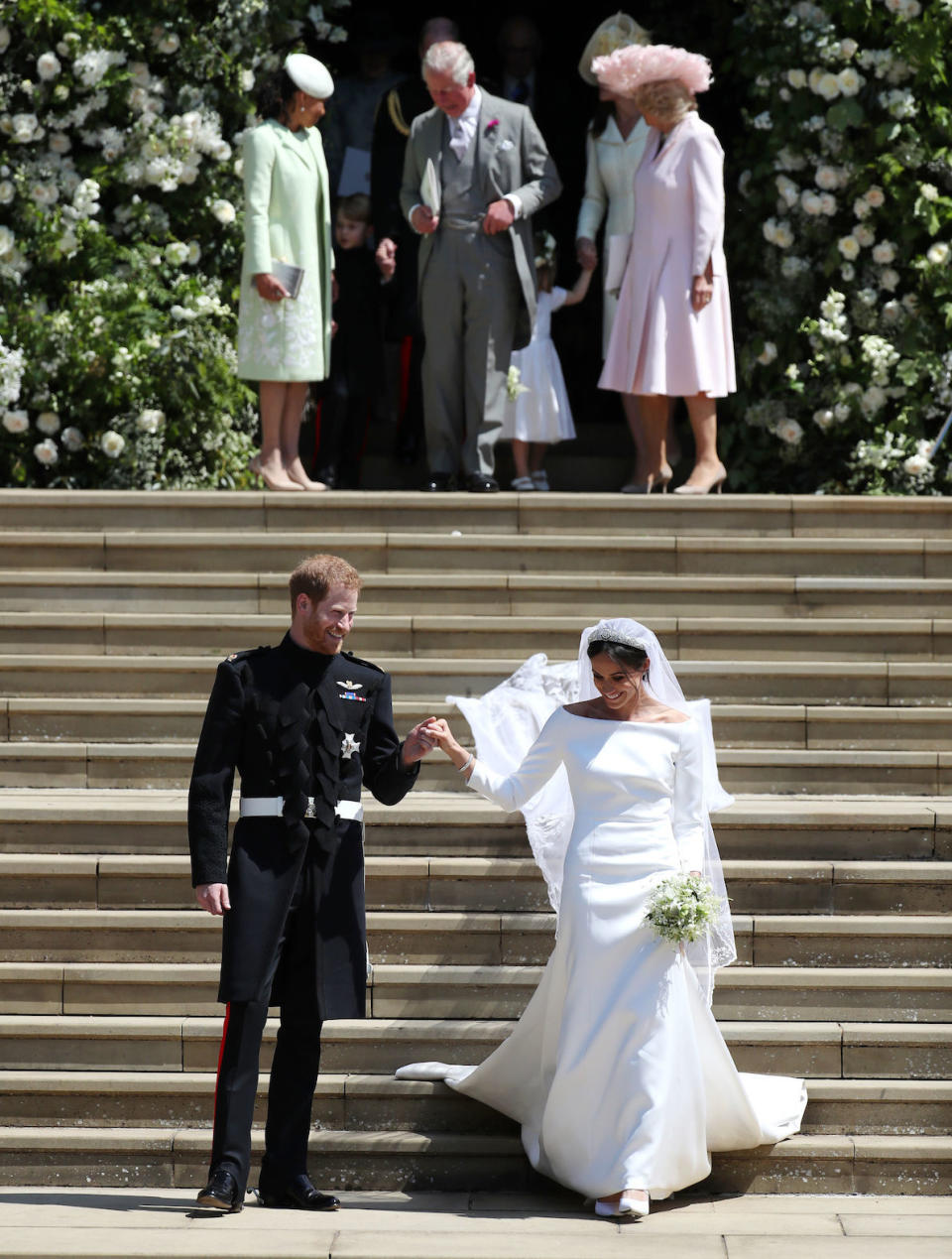 Prince Harry and Meghan Markle followed by (left-right back) Doria Ragland, mother of the bride, the Prince of Wales and the Duchess of Cornwall, after the ceremony. (Getty)