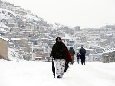 An Afghan woman walks on a snowy day in Kabul, Afghanistan February 5, 2017.REUTERS/Omar Sobhani