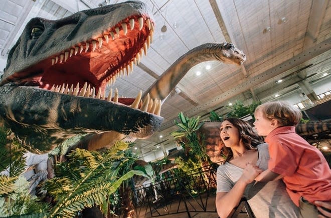 A mother and child are wowed at the site of the Giganotosaurus at Jurassic Quest.