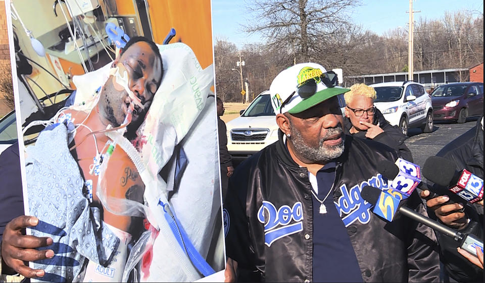 In this photo provided by WREG, Tyre Nichols' stepfather Rodney Wells, right, holds a photo of Nichols in the hospital after his arrest, during a protest in Memphis, Tenn., Saturday, Jan. 14, 2023. (Jordan James/WREG via AP)