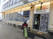 A man delivers a supply of heating gas to Warsaw's popular Piw Paw pub in Warsaw, Poland, Monday, Jan. 25, 2021, a business that is struggling to survive under lockdown by organizing legal, small-scale educative meetings and courses for beer lovers. (AP Photo/Czarek Sokolowski)