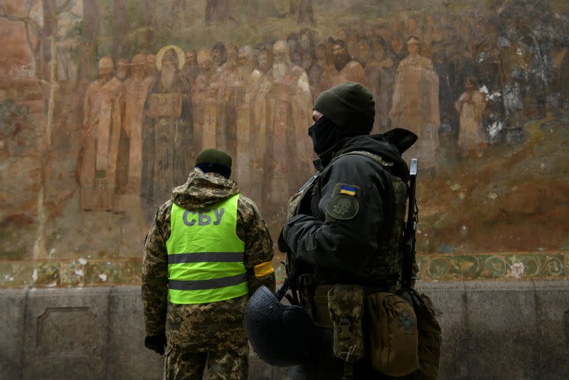 Ukrainian law enforcement officers stand next to an entrance to the Kyiv Pechersk Lavra monastery compound in Kyiv