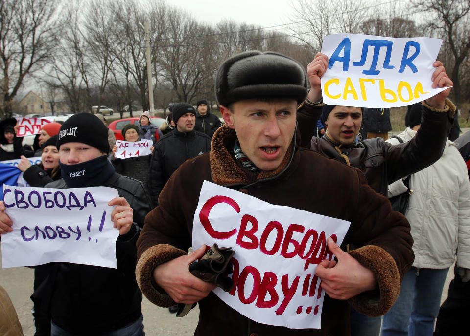 Crimean Tatars shout slogans and hold banners which reads: "Freedom of speech" during the pro-Ukraine rally in Simferopol, Crimea, Ukraine, Monday, March 10, 2014. Russian President Vladimir Putin on Sunday defended the separatist drive in the disputed Crimean Peninsula as in keeping with international law, but Ukraine's prime minister vowed not to relinquish "a single centimeter" of his country's territory. The local parliament in Crimea has scheduled a referendum for next Sunday.(AP Photo/Darko Vojinovic)