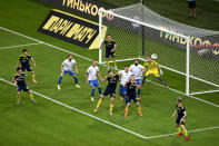 FC Sochi players, in white shirt, try to score against Rostov during a Russia Soccer Premier League soccer match against FC Rostov as the league was resumed after a three-month hiatus because of the coronavirus pandemic in Sochi, Russia, Friday, June 19, 2020. Rostov fielded a team of teenagers because its entire first-team squad is in isolation following a suspected outbreak of coronavirus. The match is being played with a minimum spectators to curb the spread of COVID-19. (AP Photo)