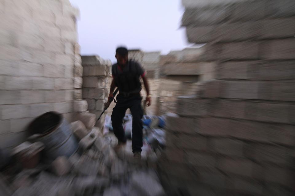 A Free Syrian Army fighter walks on the rubble of damaged buildings near Nairab military airport, which is controlled by forces loyal to Syria's President Bashar al-Assad, in Aleppo, September 4, 2013. REUTERS/Hamid Khatib (SYRIA - Tags: POLITICS CIVIL UNREST)