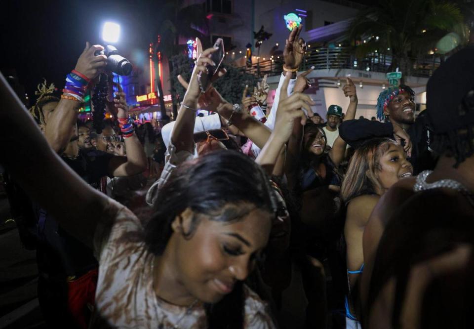 A group of people films videos and dances on Ocean Drive during spring break on Sunday, March 19, 2023, in Miami Beach.
