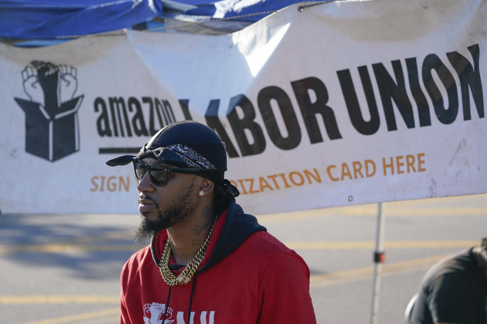 Chris Smalls, president of the Amazon Labor Union, stands by an information booth collecting signatures across the street from an Amazon distribution center in the Staten Island borough of New York, Thursday, Oct. 21, 2021. A bid to unionize Amazon workers at the distribution center in New York City neared an important milestone, as organizers prepared to deliver hundreds of signatures to the National Labor Relations Board as soon as Monday for authorization to hold a vote. (AP Photo/Seth Wenig)