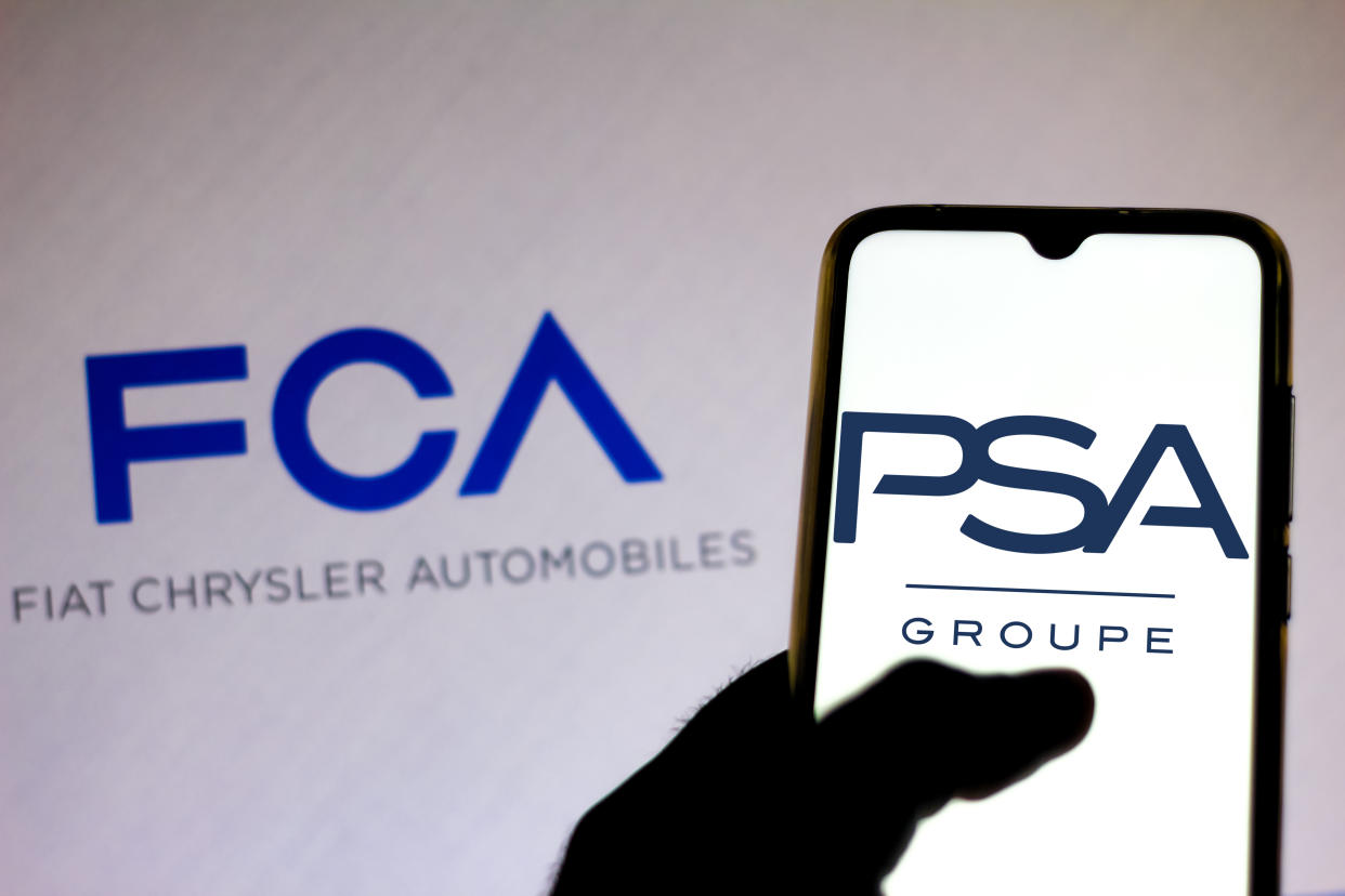 BRAZIL - 2019/12/18: In this photo illustration the Groupe PSA logo is viewed on a smartphone and Fiat Chrysler Automobiles logo on a blurred background. (Photo Illustration by Rafael Henrique/SOPA Images/LightRocket via Getty Images)