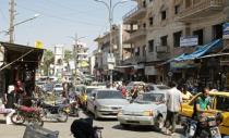 People walk along a crowded street in the city of Idlib