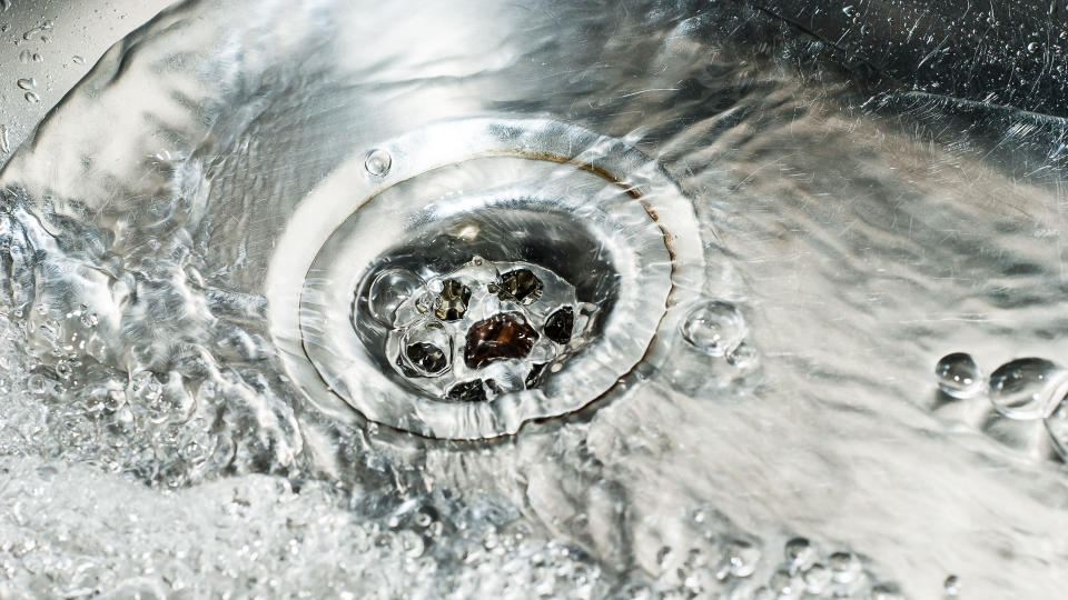 Water running down the drain in a stainless steel sink