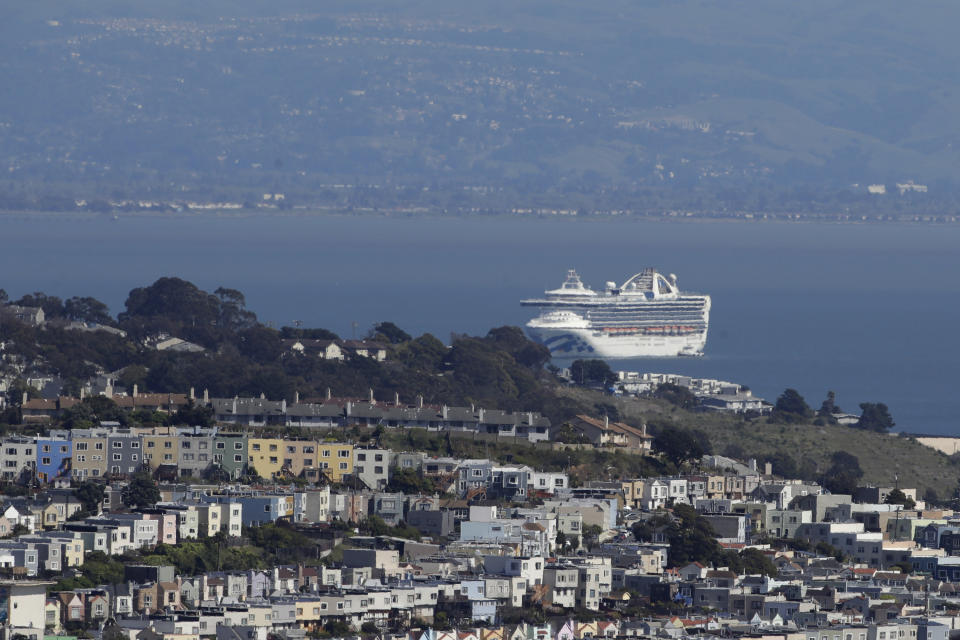 FILE - In this March 31, 2020, file photo, The Grand Princess cruise ship is shown docked in San Francisco. Nearly 650 crew members of the Grand Princess have completed their 14-day quarantine, ending a month-long period of self-isolation that began when the cruise ship was struck with the coronavirus. The cruise line said the crew members can finally leave their staterooms Saturday, April 4, and roam around the ship as long as they wear personal protective equipment and stay at least six feet from each other. The ship will leave San Francisco Bay and sail out to sea for several days of routine marine operations. (AP Photo/Jeff Chiu, File)