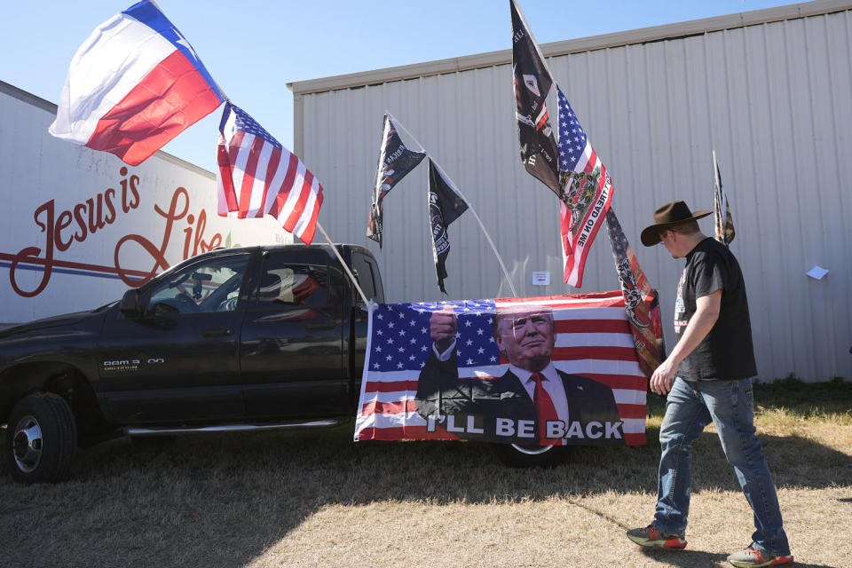 A participant passes flags and signage during a 