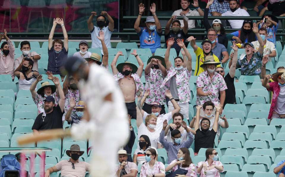 Spectators perform a "Mexican wave " during play on day two of the third cricket test between India and Australia at the Sydney Cricket Ground, Sydney, Australia, Friday, Jan. 8, 2021. (AP Photo/Rick Rycroft)