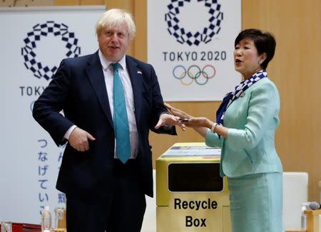 Britain's Foreign Secretary Boris Johnson (L) talks with Tokyo Governor Yuriko Koike before he feeds a smartphone into a box collecting old mobile phones from Tokyo residents, which will be recycled into medals for the 2020 Tokyo Olympics and Paralympics, during their meeting at Tokyo Metropolitan Government buildingin Tokyo, Japan July 21, 2017. REUTERS/Issei Kato