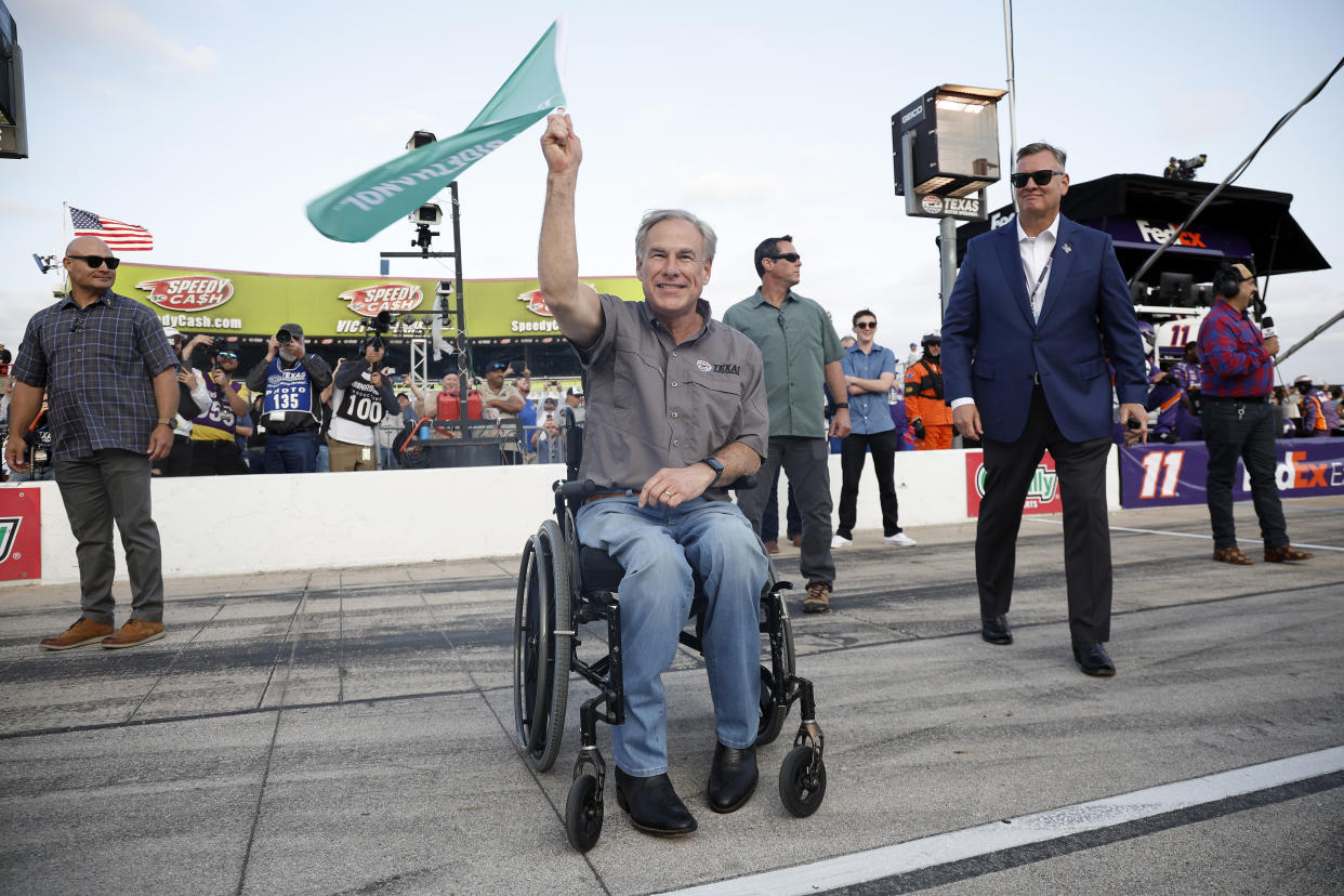 FORT WORTH, TEXAS - MAY 22: Greg Abbott, governor of Texas waves the green flag to start the NASCAR Cup Series All-Star Race at Texas Motor Speedway on May 22, 2022 in Fort Worth, Texas. (Photo by Chris Graythen/Getty Images)