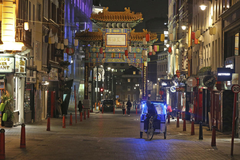 A quiet Wardour Street in London, as the New Year's Eve fireworks display has been cancelled due to the coronavirus pandemic, Thursday, Dec. 31, 2020. (Jonathan Brady/PA via AP)