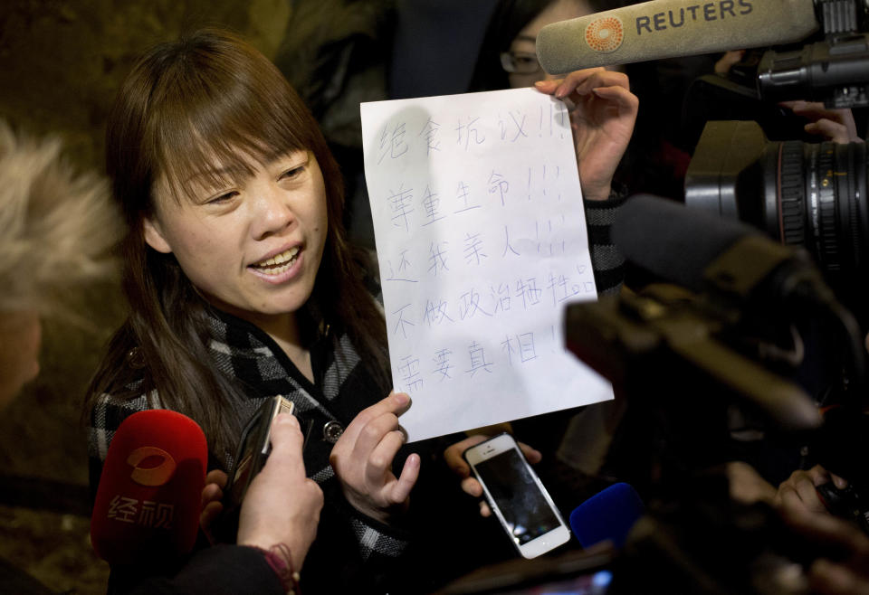 A relative of a Chinese passenger aboard the missing Malaysia Airlines Flight MH370 shows a paper reading "Hunger strike protest, Respect life, Return my relative, Don't want become victim of politics, Tell the truth" as she speaks to the media outside a hotel ballroom after attending a briefing held by airlines' officials in Beijing, China, Tuesday, March 18, 2014. Families of the passengers aboard the missing plane decided to organize a hunger strike to express their anger and disappointment at the handling of the situation by authorities. They decided on the action after a daily morning meeting with two officials from Malaysia Airlines. The plane has been missing since March 8, and contradictory information plus the fact there has been no sign of the plane has left family members frustrated. (AP Photo/Andy Wong)