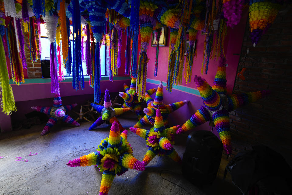 Traditional Christmas "piñatas" that will be filled with fruit and candy are displayed at a small family-run business in Acolman just north of Mexico City, Wednesday, Dec. 13, 2023. This style of piñata has a religious origin, with each cone representing one of the seven deadly sins, and hitting the globe with a stick is a symbolic blow against sin. (AP Photo/Fernando Llano)