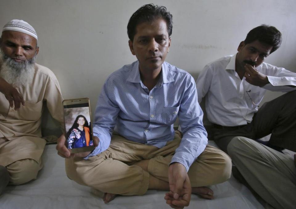 Abdul Aziz Sheikh, shows a picture of his daughter in Karachi, Pakistan.
