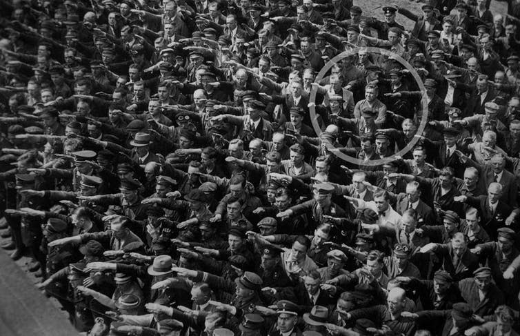 <span class="caption">People giving a Nazi salute, with an unidentified person (possibly August Landmesser or Gustav Wegert) refusing to do so.</span> <span class="attribution"><span class="source">wikipedia</span>, <a class="link " href="http://creativecommons.org/licenses/by-sa/4.0/" rel="nofollow noopener" target="_blank" data-ylk="slk:CC BY-SA;elm:context_link;itc:0;sec:content-canvas">CC BY-SA</a></span>