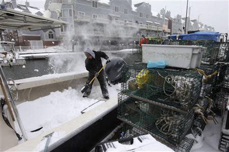 Rob McCann shovels snow off his brother's boat following a snowstorm in Portland, Maine December 15, 2013. REUTERS/Joel Page