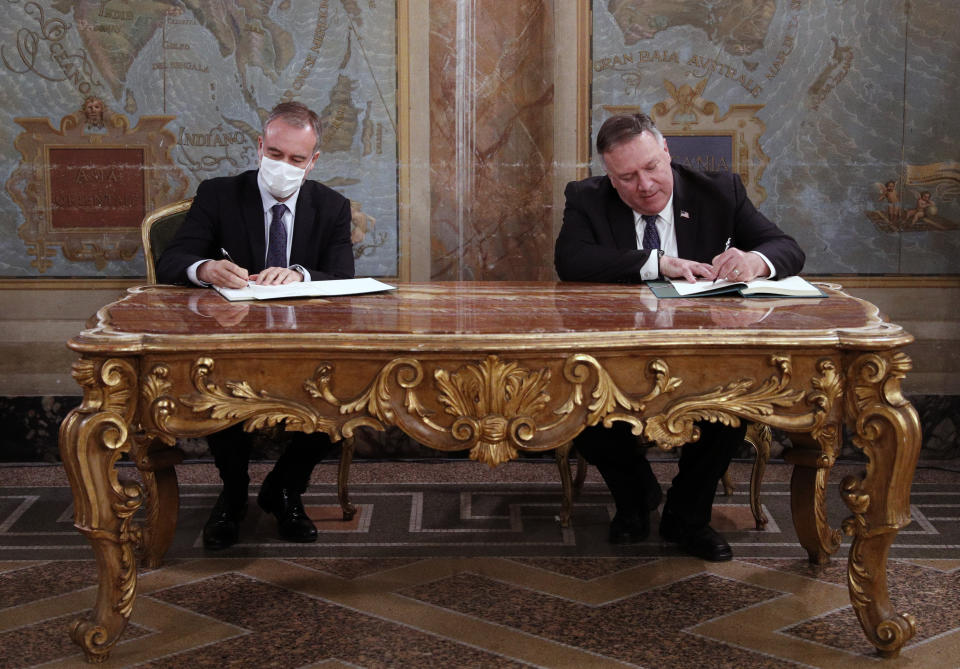 U.S. Secretary of State Mike Pompeo, right, and International Institute for the Unification of Private Law (UNIDROIT) Secretary-General, Ignacio Tirado, sign the Mining, Agriculture, and Construction (MAC) Protocol during the Signing Ceremony, at Villa San Sebastiano, in Rome, Thursday, Oct. 1, 2020. (Guglielmo Mangiapane/Pool Photo via AP)