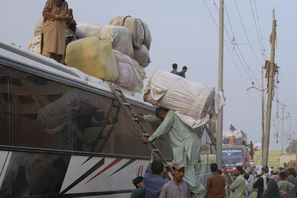 Afghans load their belongings on to a rooftop of a bus as they prepare to depart for their homeland, in Karachi, Pakistan, Wednesday, Nov. 1, 2023. Pakistani security forces on Wednesday rounded up, detained and deported dozens of Afghans who were living in the country illegally, after a government-set deadline for them to leave expired, authorities said. (AP Photo/Fareed Khan)