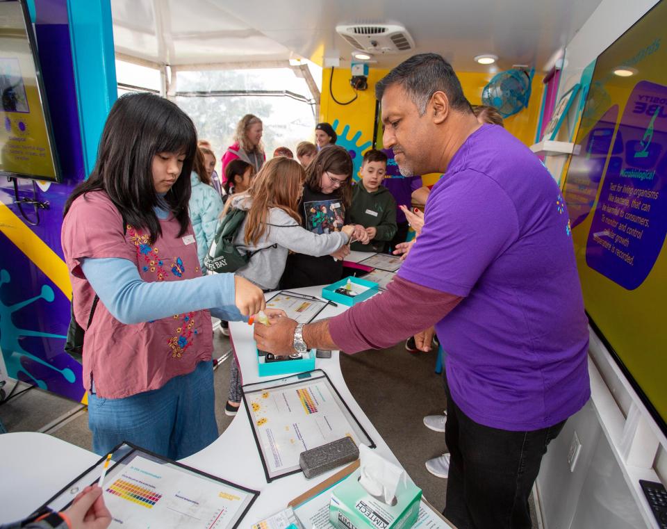 Cing Kim,8, left, gets help from MilliporeSigma’s Raj Patel as she conducts a lab experiment at Sheboygan STEAMfest at UW-Green Bay, Sheboygan campus, Thursday, October 12, 2023, in Sheboygan, Wis.