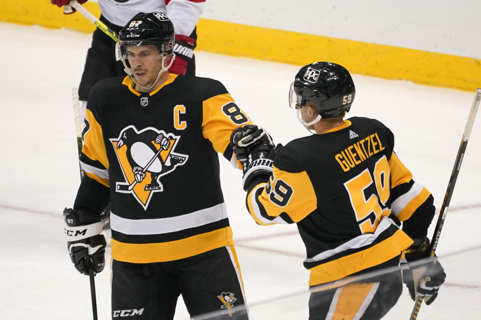Pittsburgh Penguins' Sidney Crosby (87) celebrates his goal with Jake Guentzel during the third period of an NHL hockey game against the New Jersey Devils in Pittsburgh, Tuesday, April 20, 2021. (AP Photo/Gene J. Puskar)