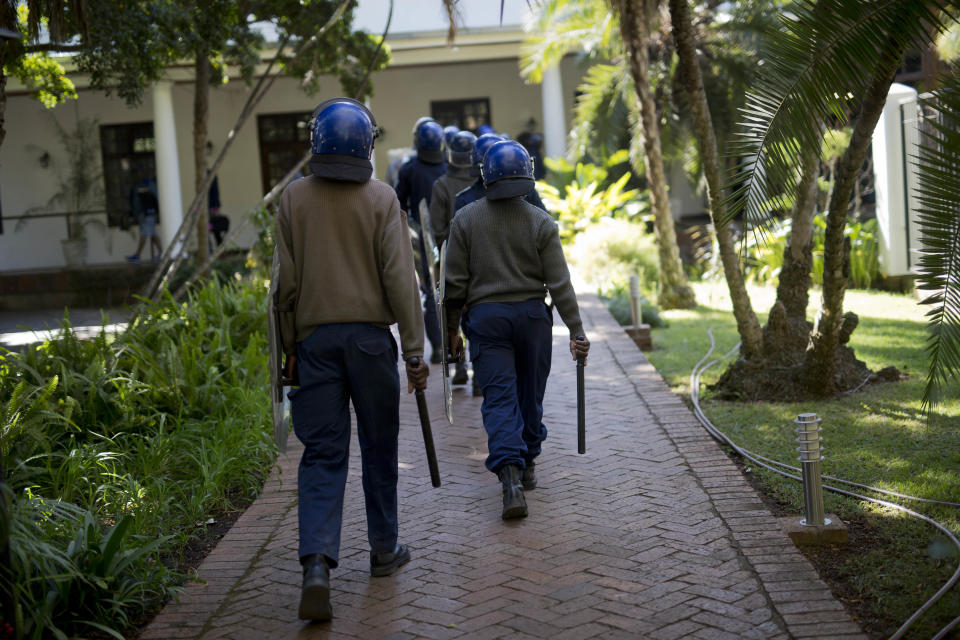 Riot police enters the Bronte hotel where a press conference by opposition leader Nelson Chamisa was scheduled to take place, in Harare, Zimbabwe, Friday Aug. 3, 2018. Hours after President Emmerson Mnangagwa was declared the winner of a tight election, riot police disrupted a press conference where opposition leader Nelson Chamisa was about to respond to the election results. (AP Photo/Jerome Delay)