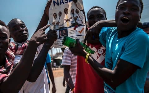 Supporters of Kenyan Opposition leader Raila Odinga shout and gesture during a protest at Kondele on August 9, 2017 in Kisumu, Kenya - Credit: AFP