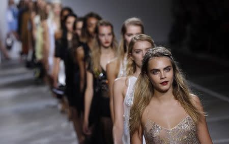 Cara Delevingne leads models in the finale of the Topshop Unique Spring/Summer 2015 collection presentation during London Fashion Week September 14, 2014. REUTERS/Suzanne Plunkett