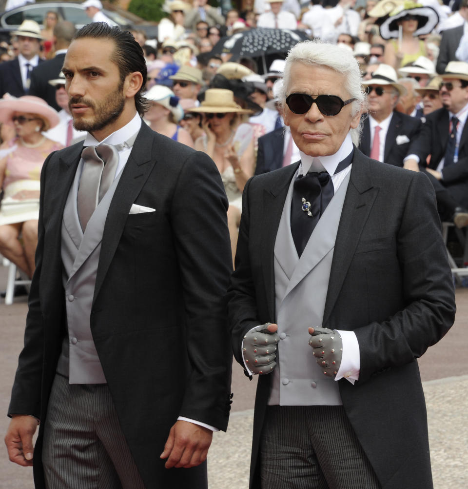 German fashion designer Karl Lagerfeld and his assistant Sebastien Jondeau arrive for the religious wedding of Prince Albert II of Monaco and Princess Charlene of Monaco at the Prince's Palace on July 2, 2011 in Monaco.  AFP PHOTO / DAMIEN MEYER