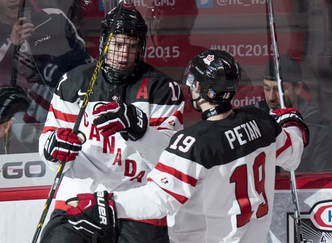 Team Canada&#39;s Connor McDavid, left, celebrates his goal against Team Germany with teammate Nic Petan during first period preliminary round hockey action at the IIHF World Junior Championship Saturday, December 27, 2014 in Montreal. THE CANADIAN PRESS/Paul Chiasson