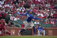 Toronto Blue Jays' George Springer follows through on an RBI single during the ninth inning of an opening day baseball game ;asl Thursday, March 30, 2023, in St. Louis. (AP Photo/Jeff Roberson)