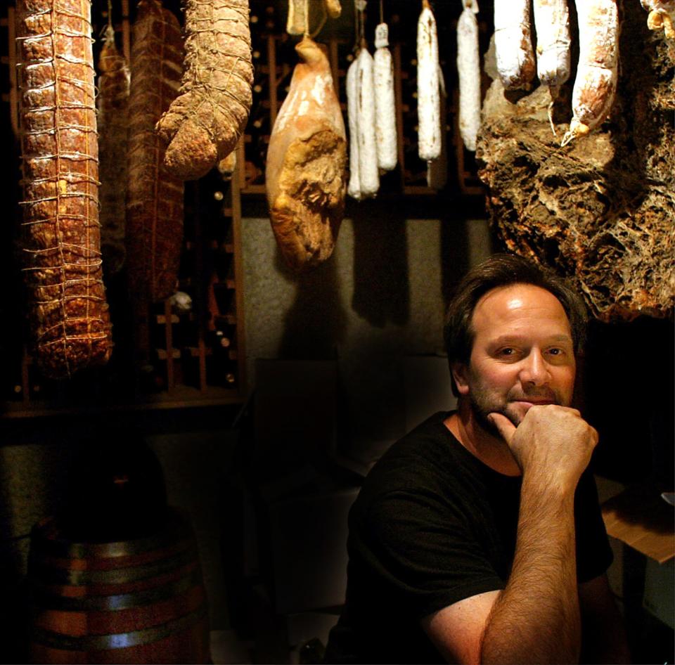 A man with his chin resting in his hand sits in the cellar at his home.