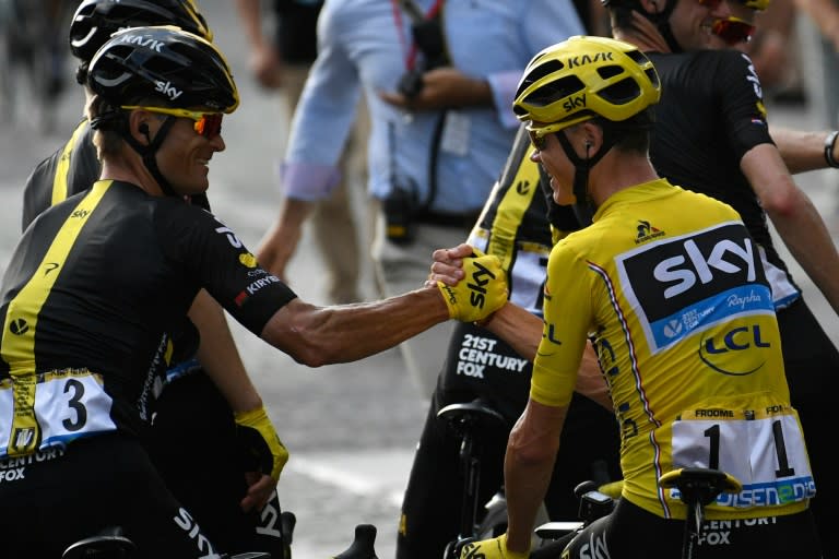 Great Britain's Chris Froome (R) shakes hands with Vasil Kiryienka (L) as they celebrates with teammates of Great Britain's Sky cycling team on July 24, 2016