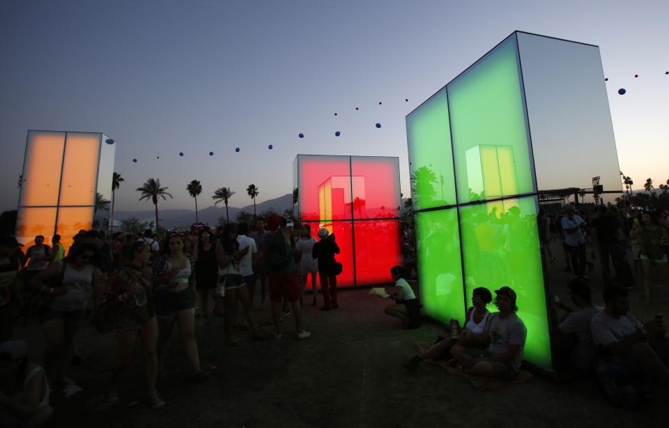 People mingle by a light installation called "Reflection Field" by artist Phillip K. Smith III at the Coachella Valley Music and Arts Festival in Indio, California April 13, 2014. Picture taken April 13, 2014. REUTERS/Mario Anzuoni (UNITED STATES - Tags: ENTERTAINMENT)