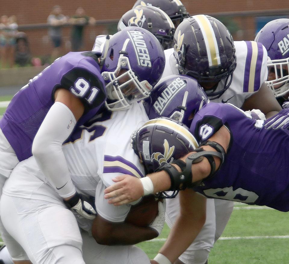 Mount Union's Nick Brown, left, and Matt Lilja, right, wrap up Defiance's Tyshaun Freeman during the first game of the year against Defiance College Saturday afternoon, September 3, 2022 at Kehres Stadium.