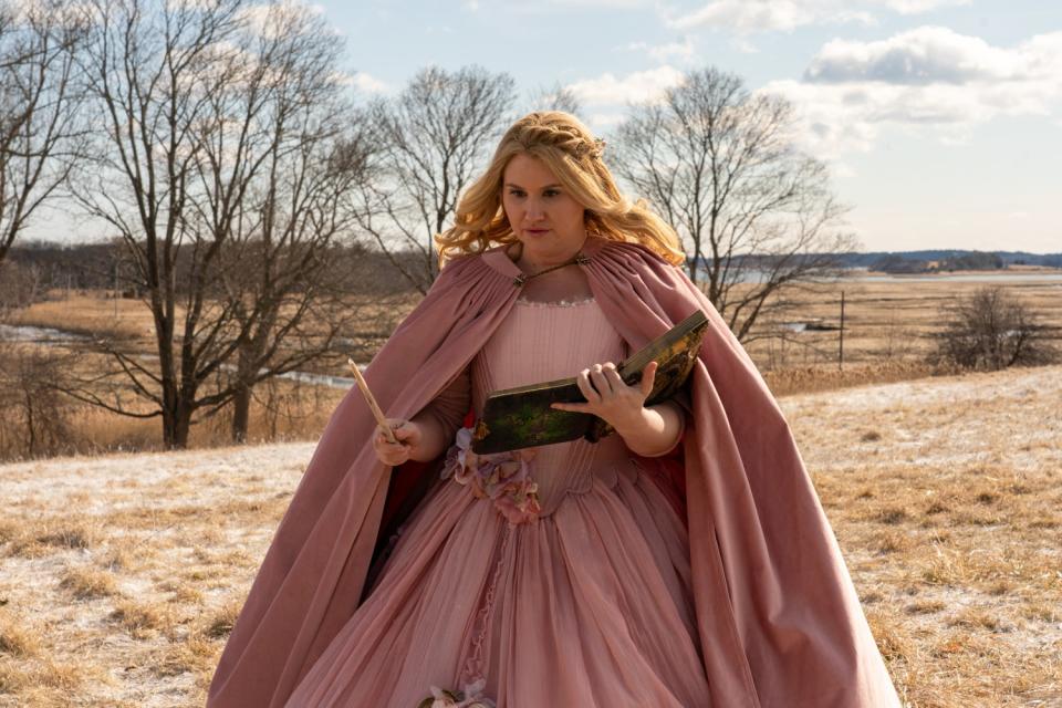 Jillian Bell holds a wand and book